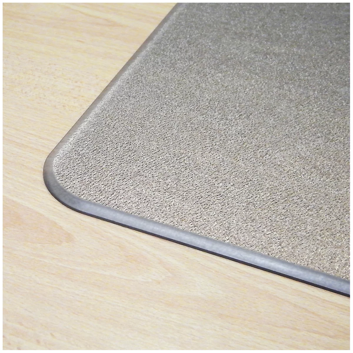 Gros plan d'un coin d'un tapis gris clair avec un bord arrondi et une bordure plus foncée. Le tapis est posé sur un sol en bois clair.