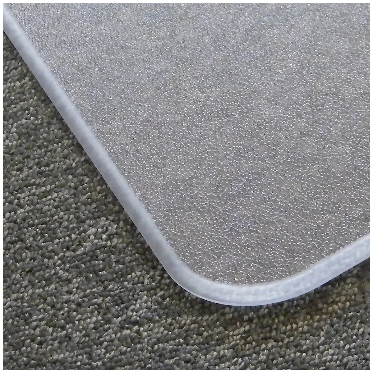 Gros plan d'un tapis de protection de sol transparent avec une bordure blanche, posé sur un tapis gris.