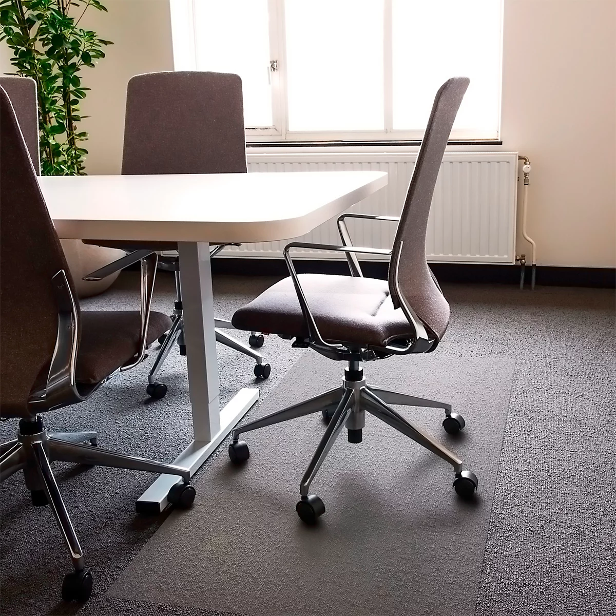 Chaises de bureau autour d'une table devant une fenêtre. Le tapis est bicolore.