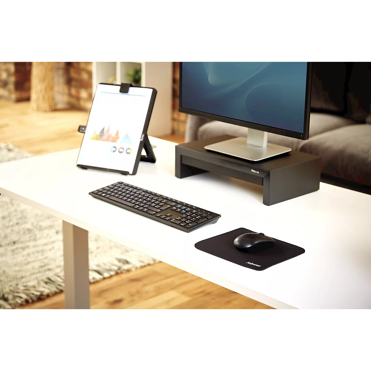 Main sur une souris noire avec tapis de souris.