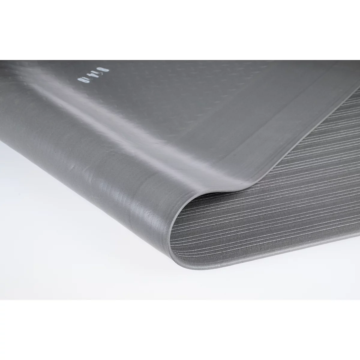 Gros plan d'un tapis en caoutchouc gris et flexible, avec une texture de surface finement rainurée.