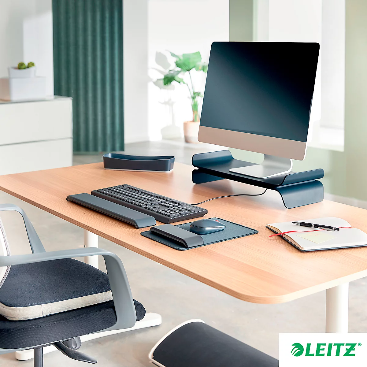 Bureau de bureau avec moniteur, clavier, souris, documents et stylo. Logo Leitz.