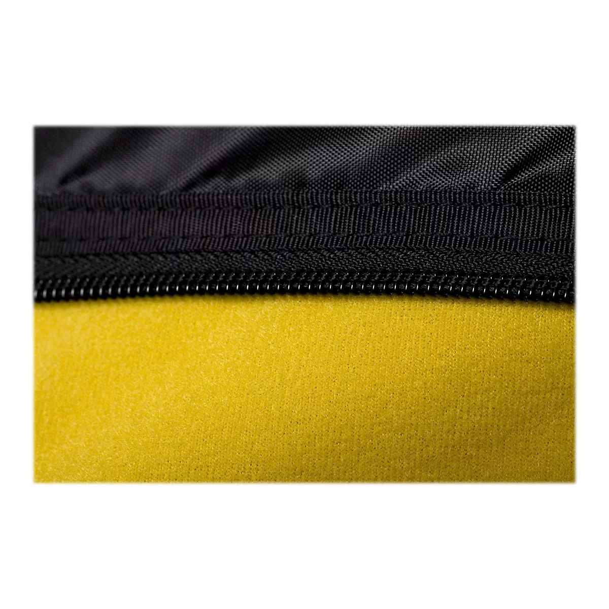 Detailaufnahme einer schwarzen Naht mit Reißverschluss, der auf gelbem Schaumstoff verläuft.