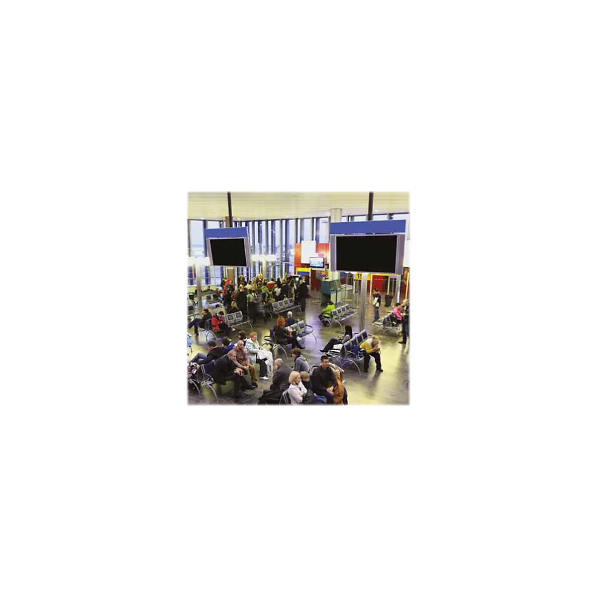 Flughafen-Wartebereich mit vielen sitzenden Passagieren und großen Anzeigebildschirmen an der Decke.