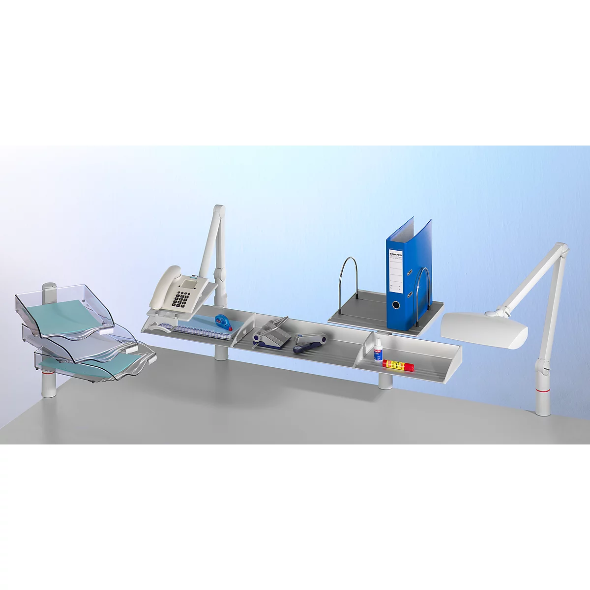 A white desk with trays, lamp, phone, and binder. Blue accents from papers and binder.