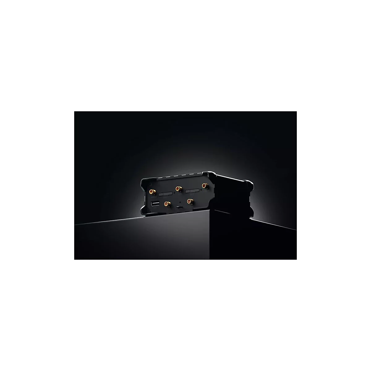 Schwarzes technisches Gehäuse mit goldenen Antennenanschlüssen und USB-Port auf einem schwarzen Sockel.