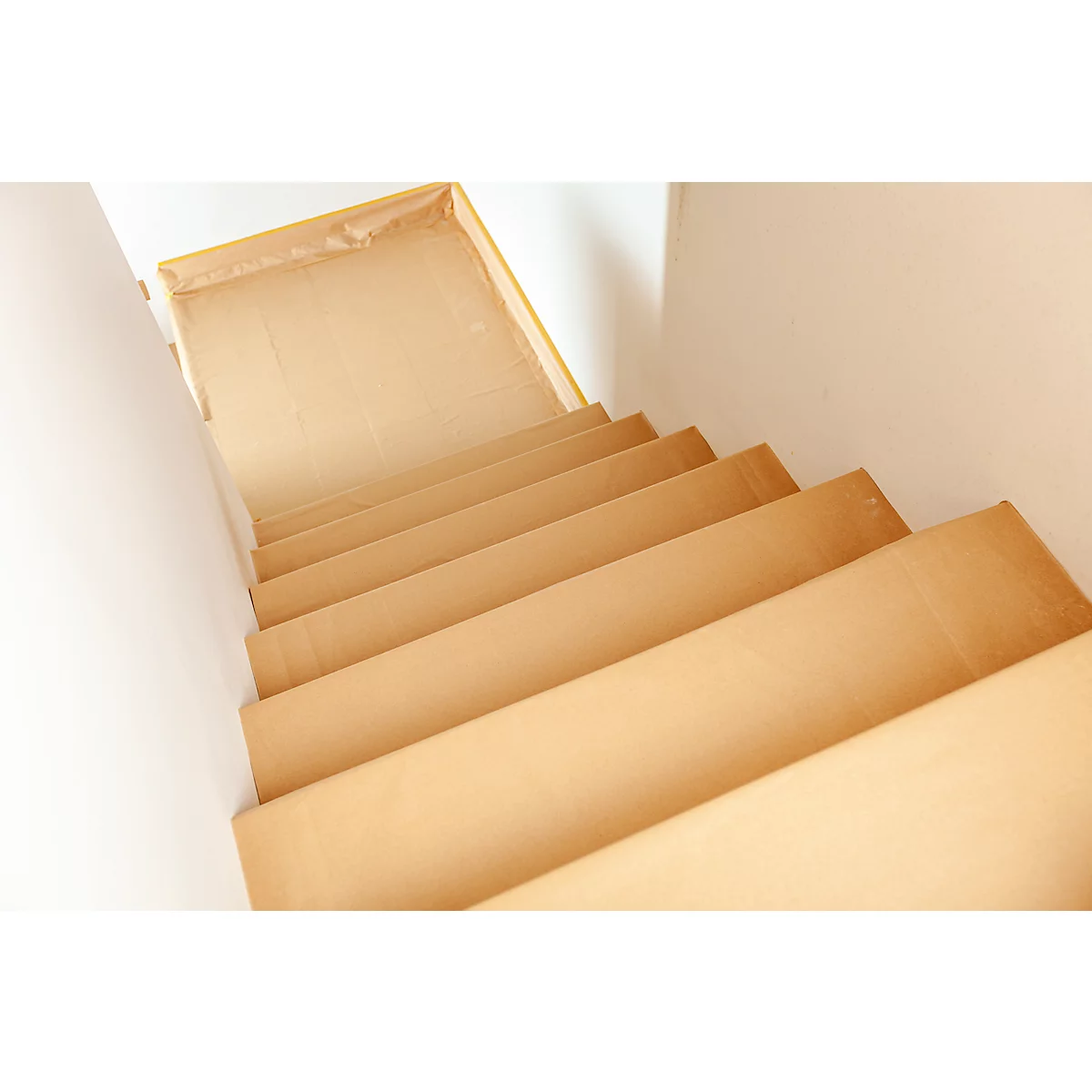 Draufsicht auf eine Holztreppe mit hellen Holzstufen. Die Wände sind weiss.