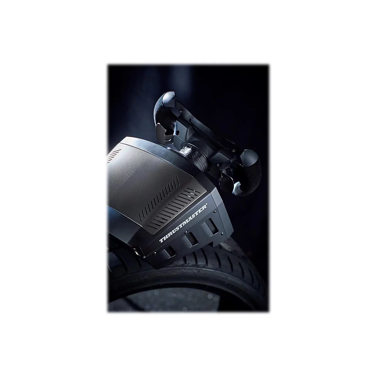 Thrustmaster Lenkradbasis montiert auf einem Reifen vor dunklem Hintergrund.