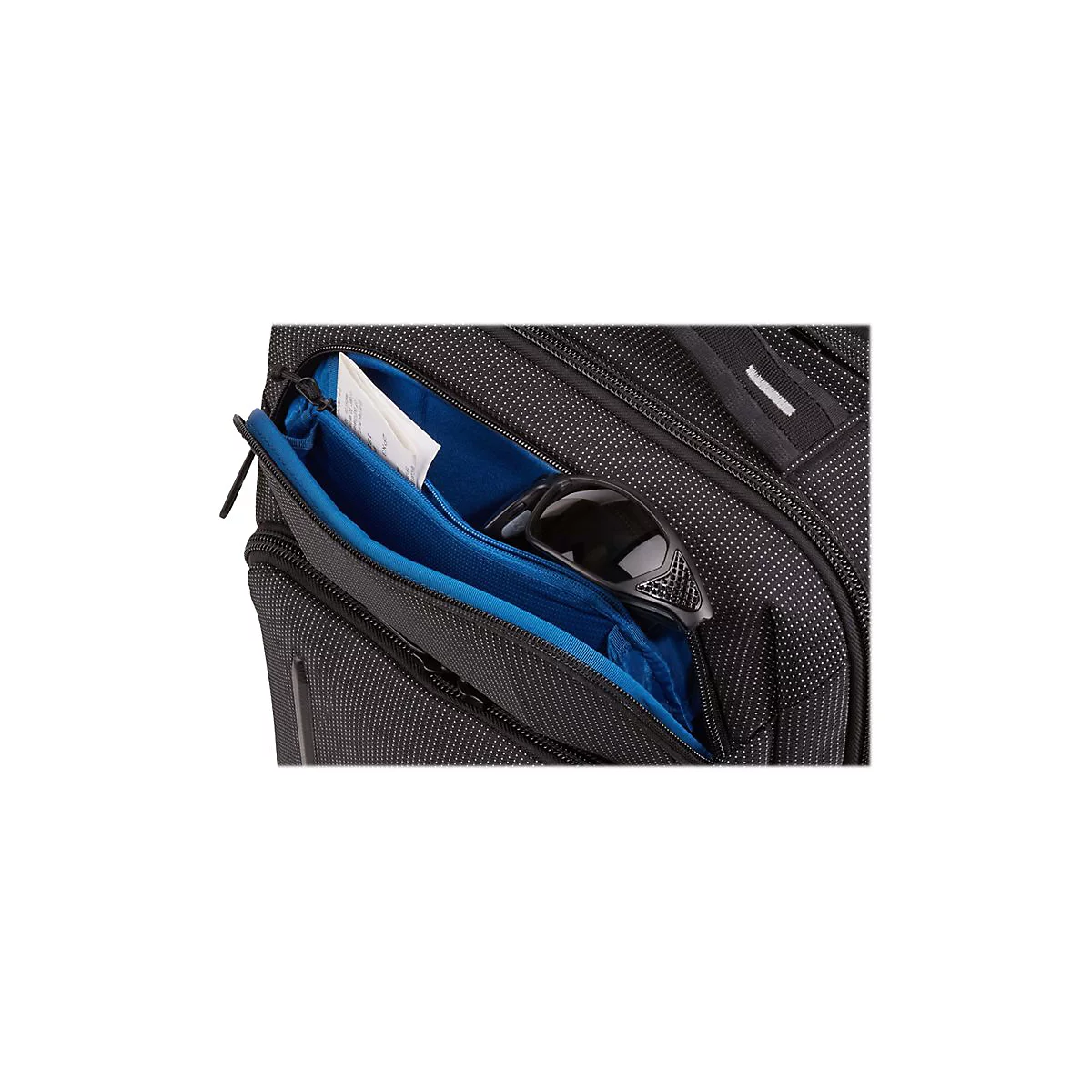 Schwarze Tasche mit geöffneter blauer Innentasche, Sonnenbrille und Zettel.