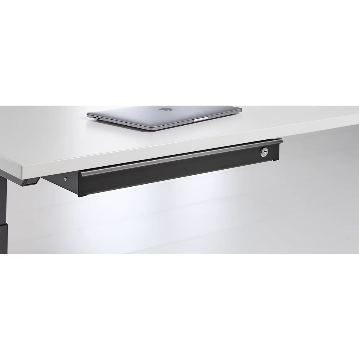 Gros plan d'un système de tiroir noir sous la table avec un trou de serrure.