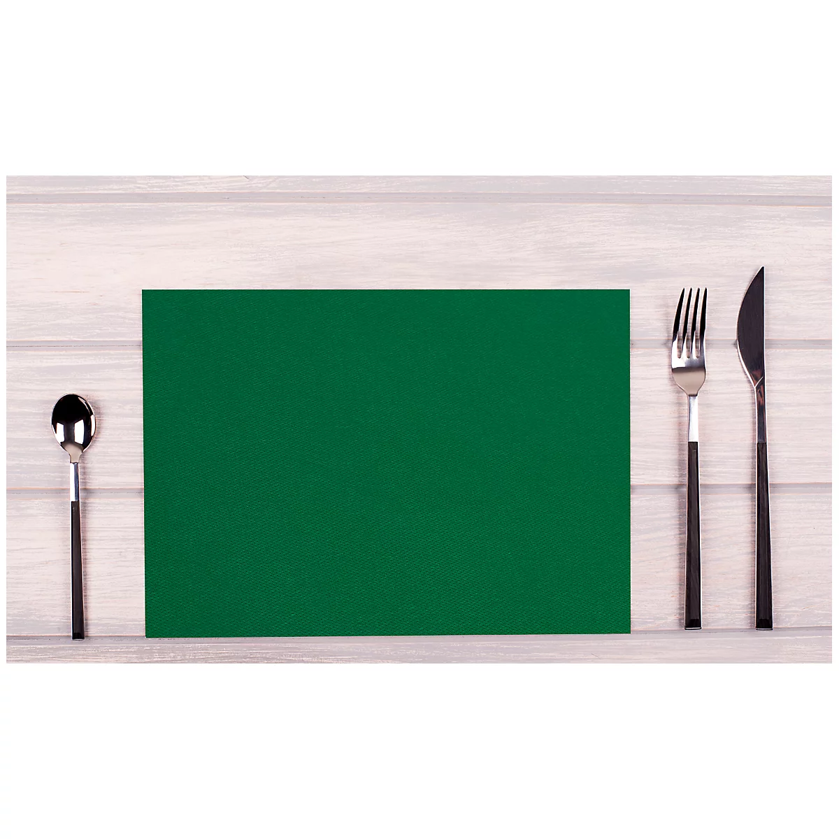 Auf einem Tisch liegt eine grüne Platzmatte, rechts davon eine Gabel und ein Messer, links ein Löffel.