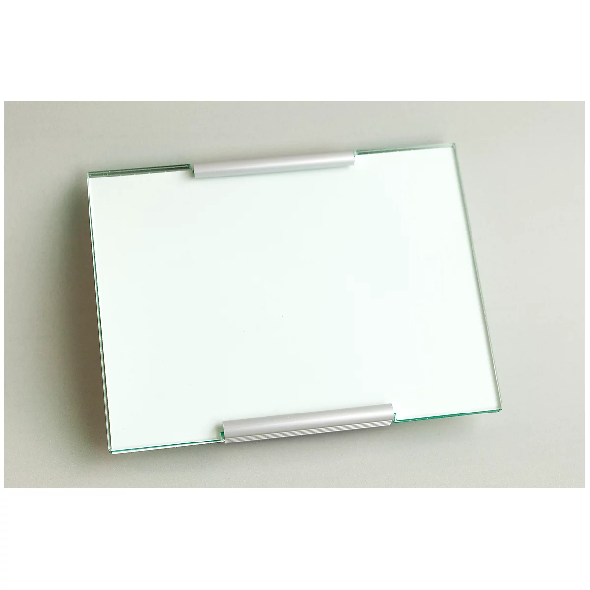 A rectangular glass plate with silver holders. The plate is placed slightly diagonally on a gray background.