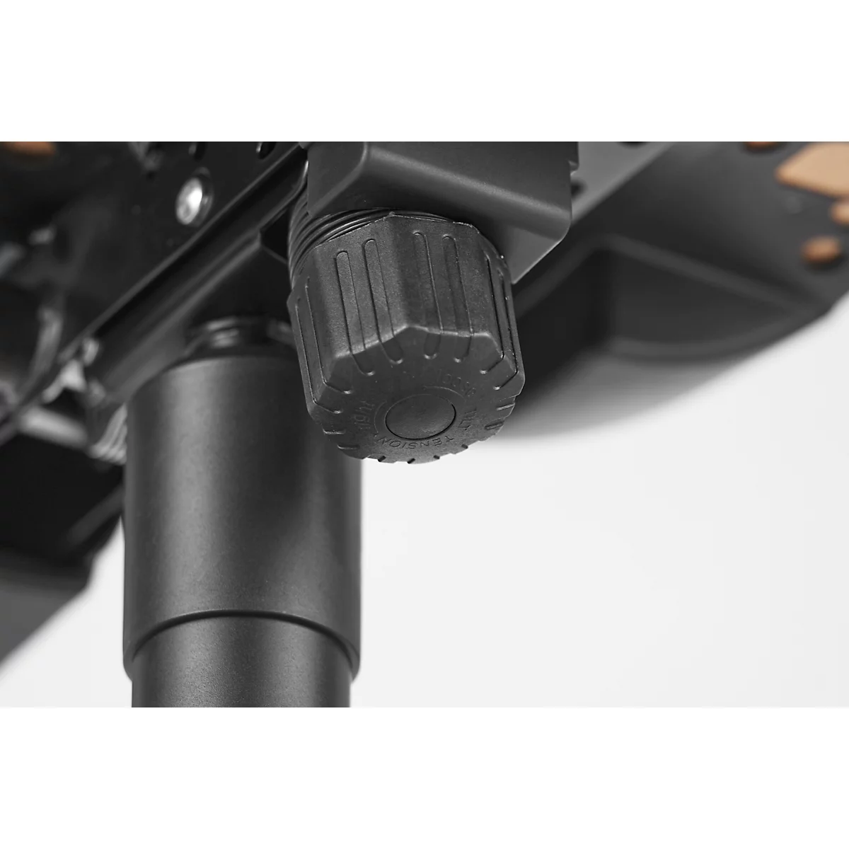 Close-up of the black adjustment knob of an office chair. The knob is ribbed for better grip. Behind it, part of the chair base.