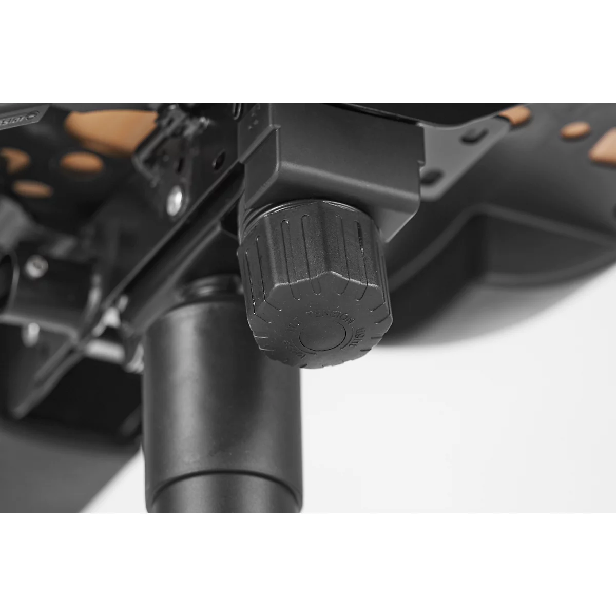 Close-up of a black chair adjustment. The ribbed knob dominates the view.