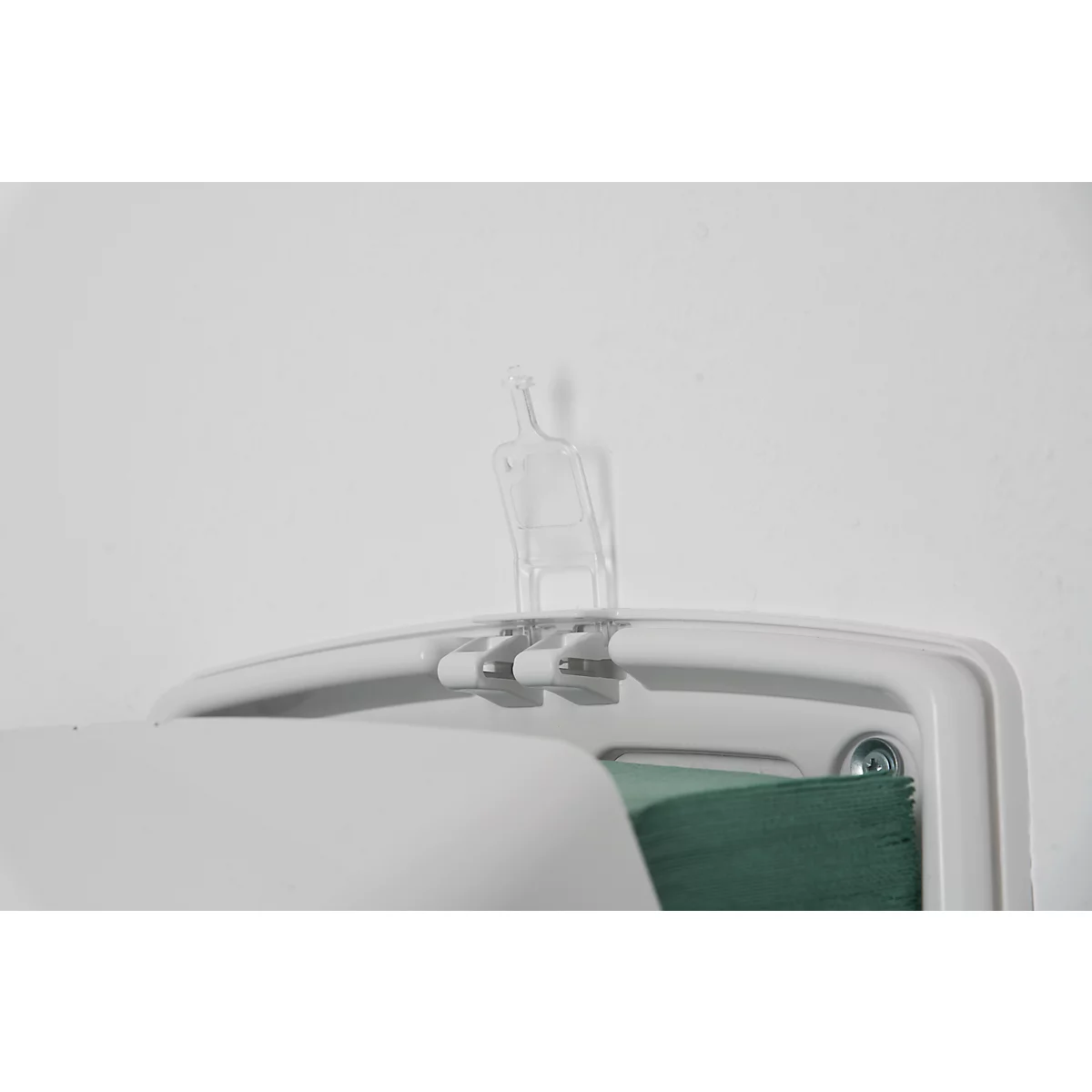 Detail shot of a white paper towel dispenser with a transparent plastic dispensing arm.