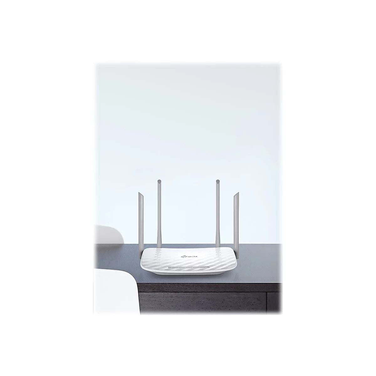 WeiÃŸer WLAN-Router mit vier Antennen auf einem Tisch. Das GerÃ¤t steht vor hellem Hintergrund.