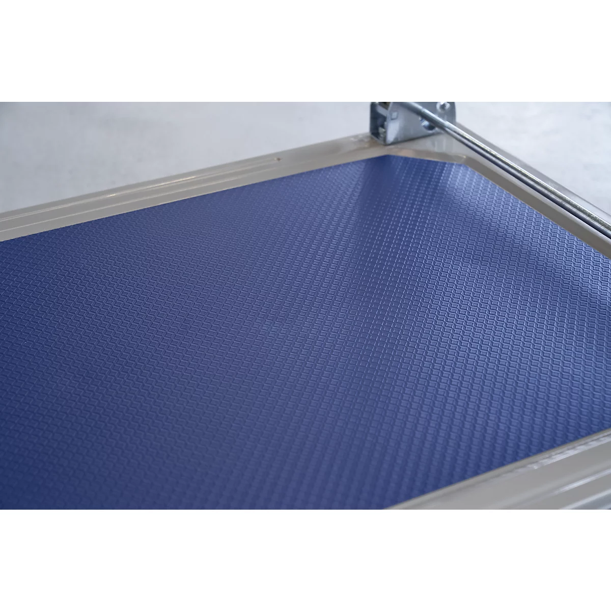 Blue textured surface in a silver frame. A metal part is visible in the top right corner.