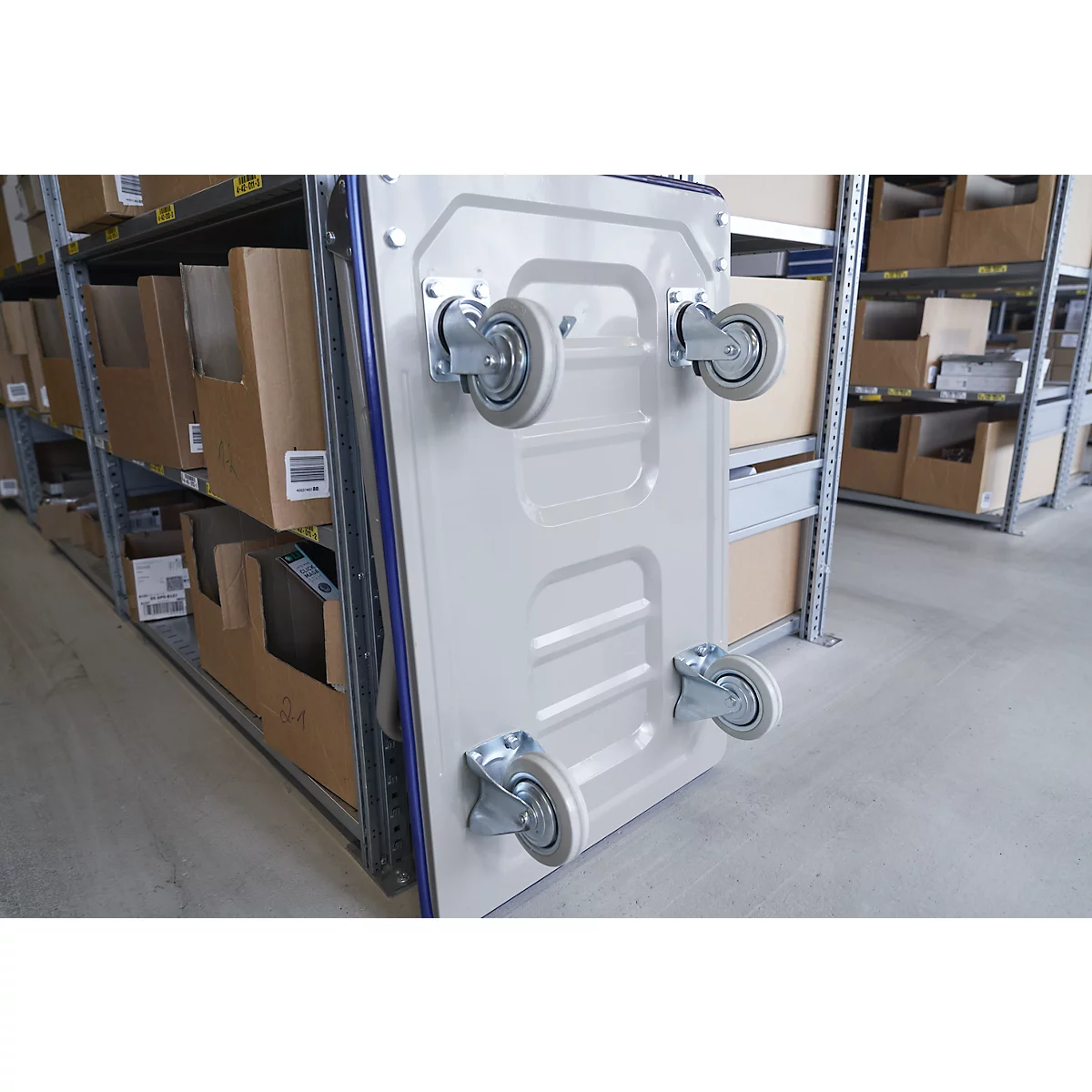 Beige transport cart with four wheels, in front of shelves with boxes.