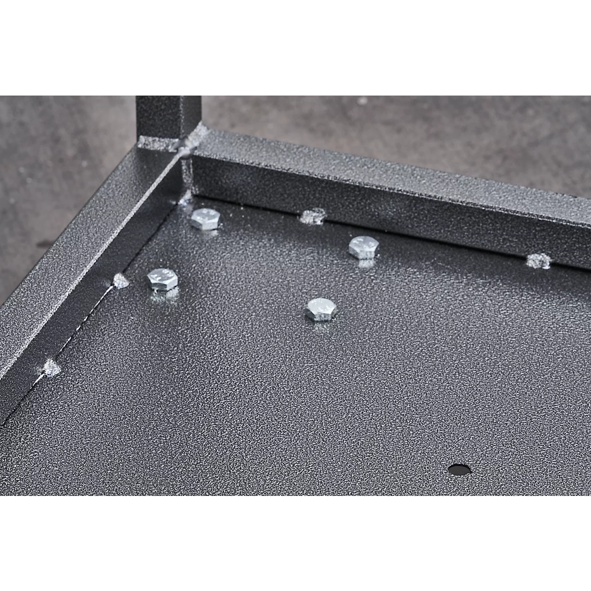 Close-up of a metal plate with screws and an angle piece.