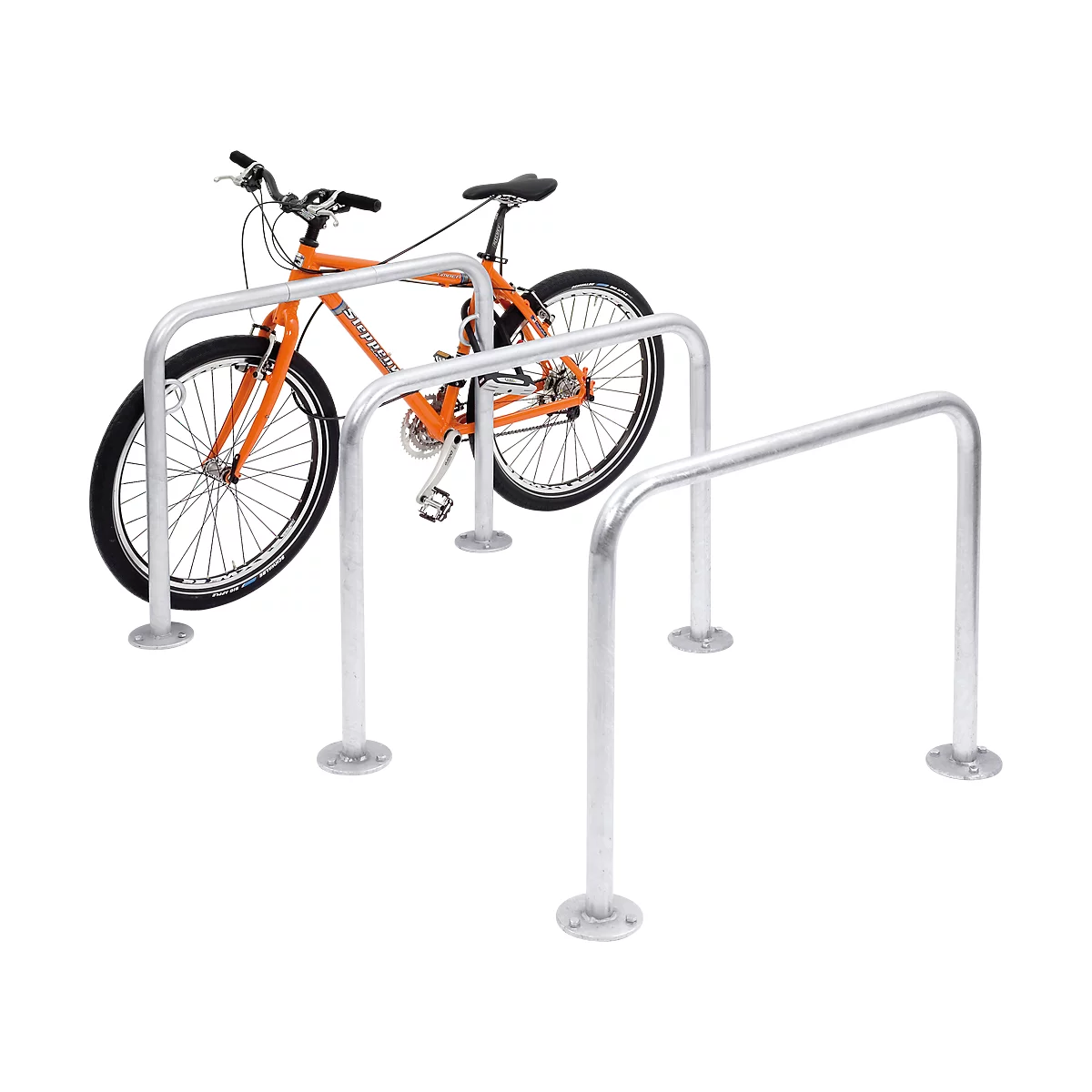 An orange bike rests in a silver bike rack. Two more racks next to it.
