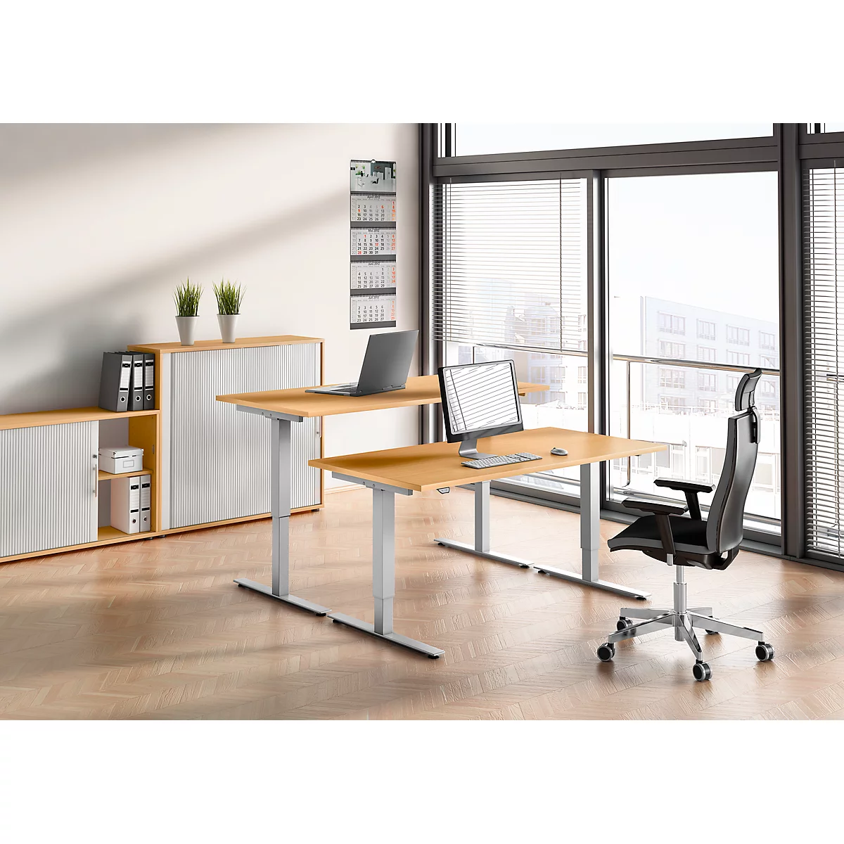Office interior with desk, chair, laptop and monitors. Bright office setup with sliding door cabinet and window.