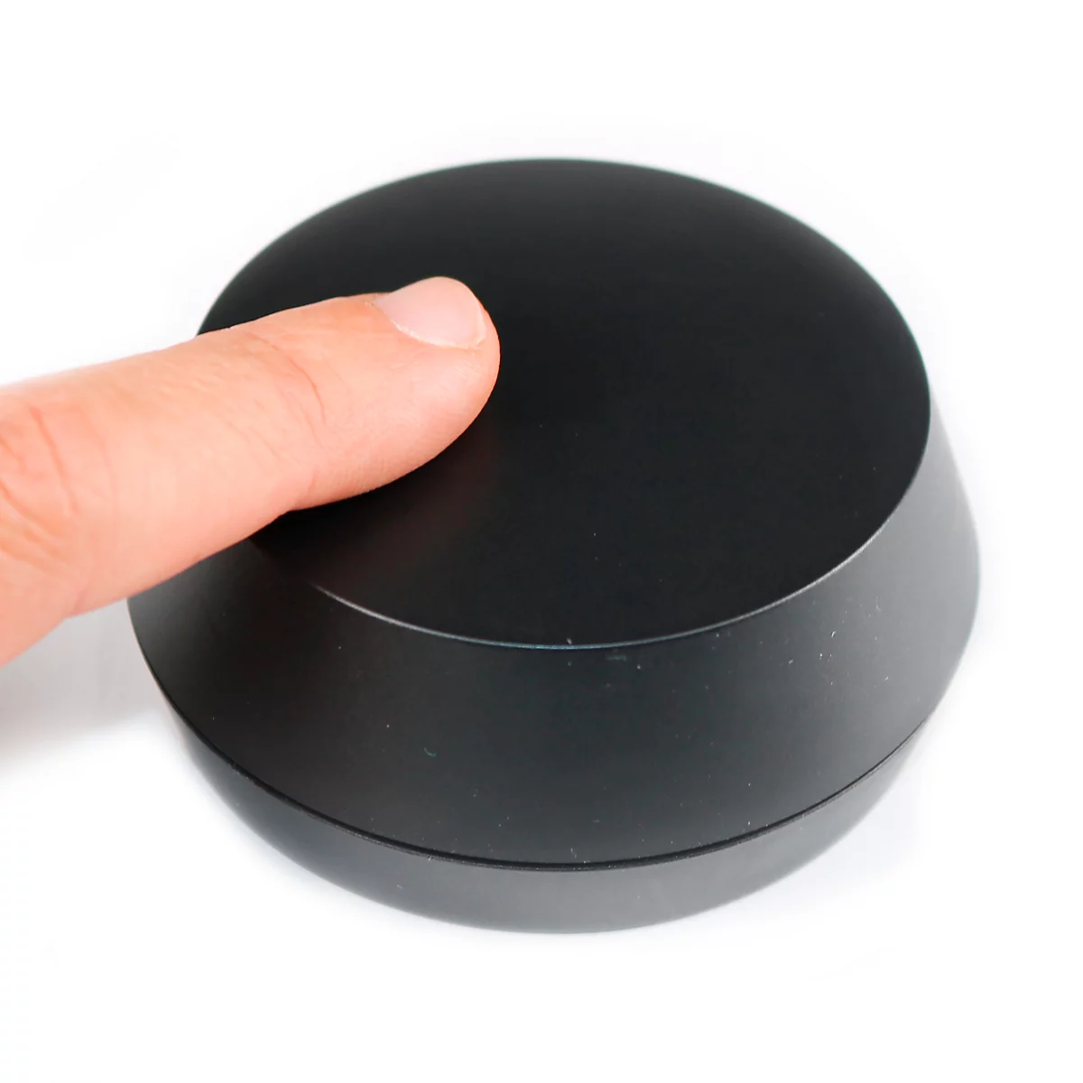 Bouton noir, doigt touchant la surface.