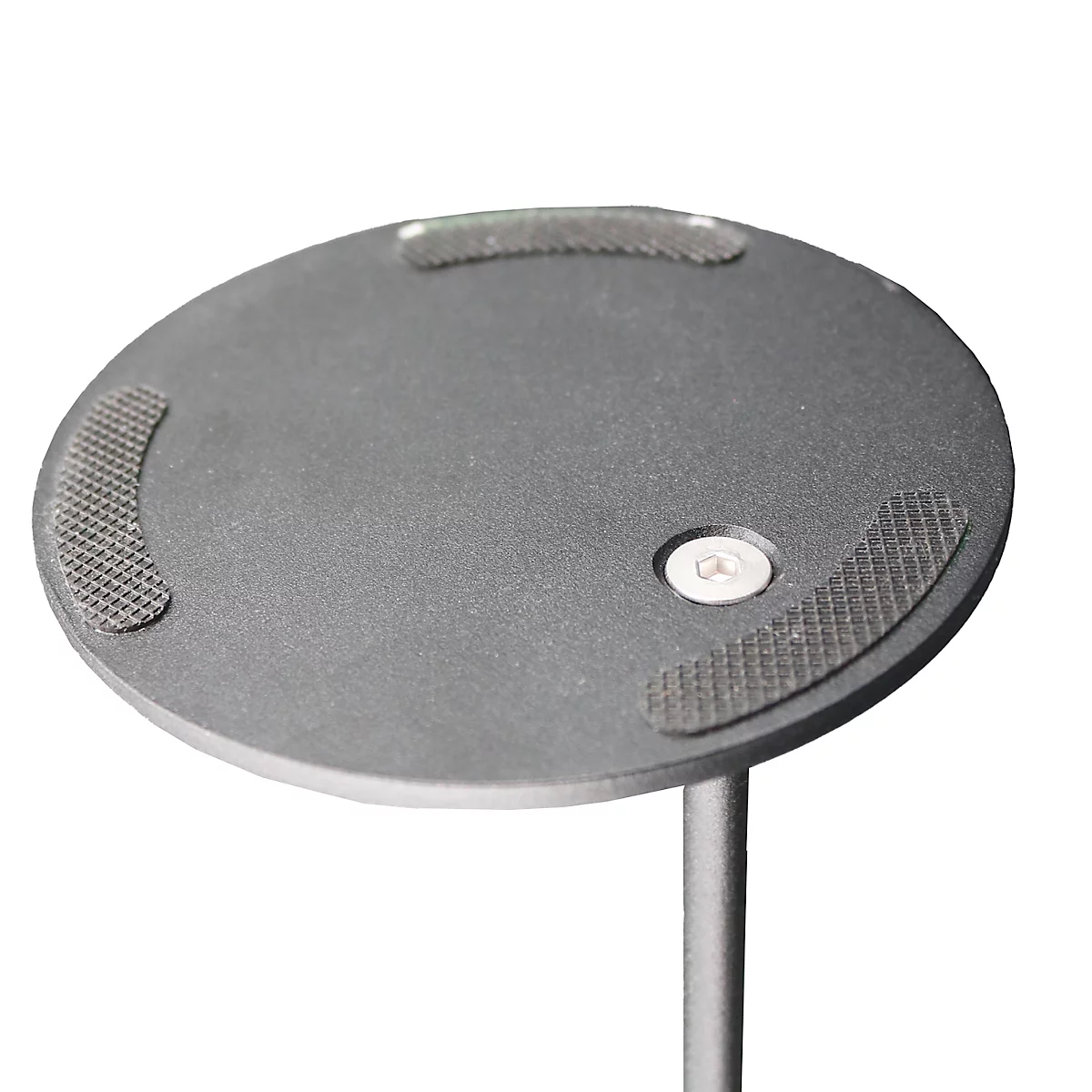 Close-up van een grijze ronde plaat met drie antislip pads en een zilveren bout.