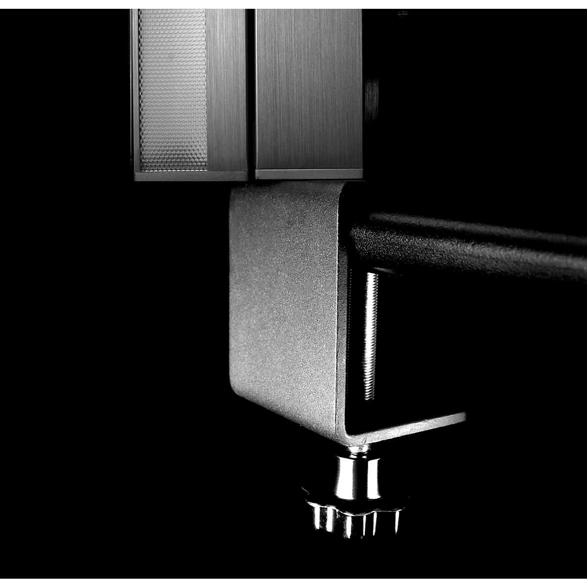 Close-up of a metallic object against a black background. The focus is on the details, highlighting textures and shapes.