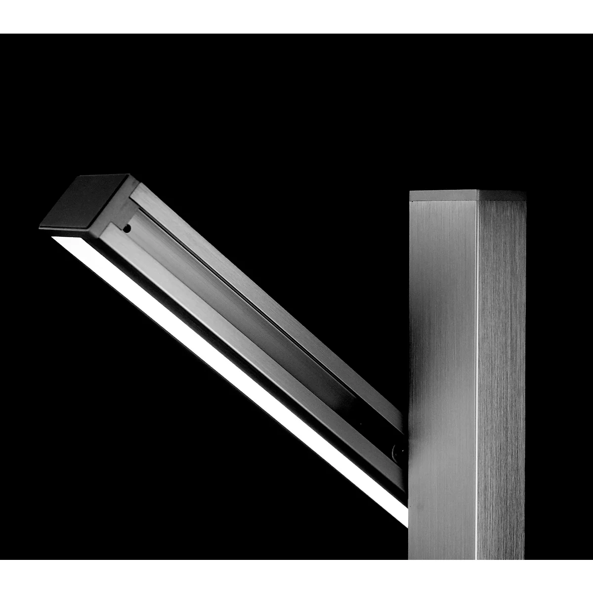 Close-up of a modern, angular light fixture with LED lighting, attached to a vertical, metallic post.