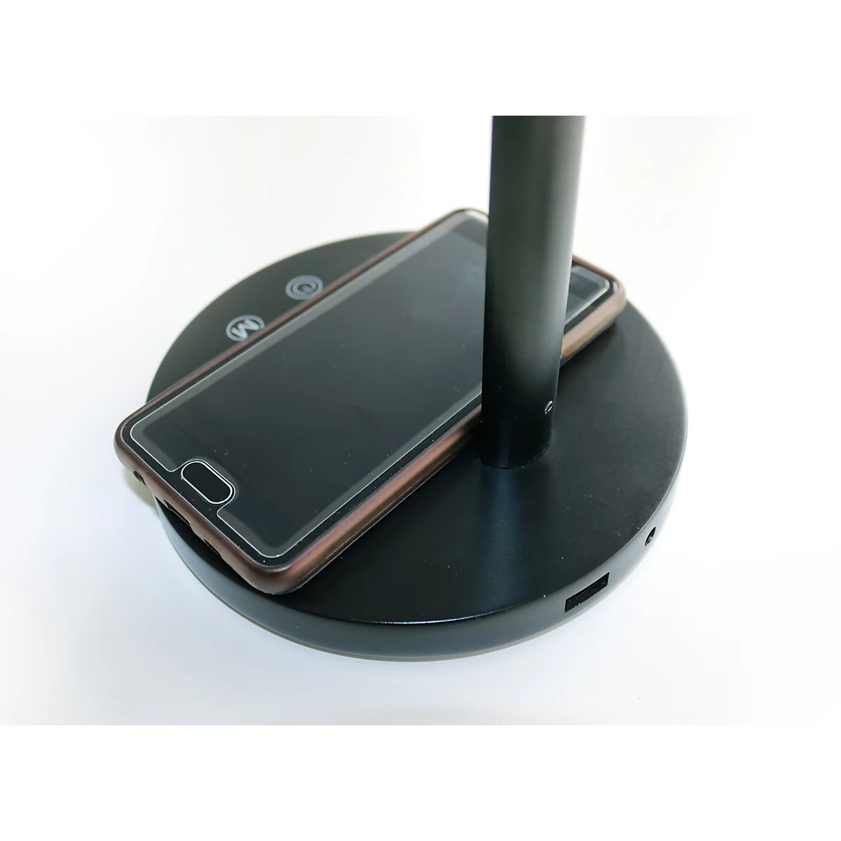Schwarzer Leuchtenfuß mit integrierter kabelloser Smartphone-Ladestation.