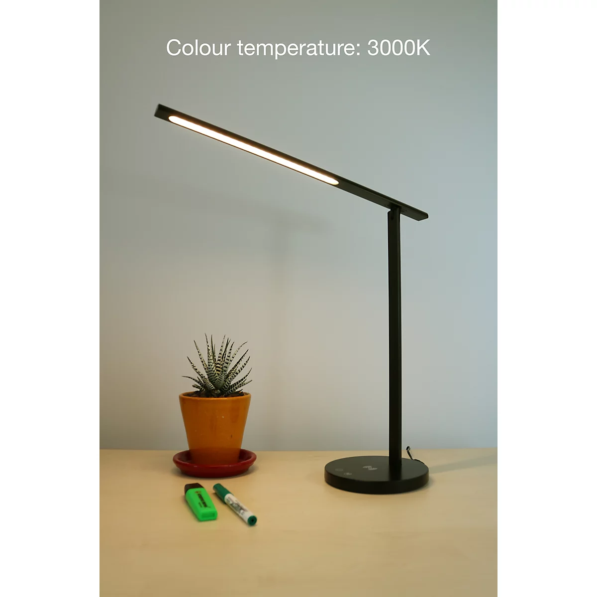 Schwarze LED-Schreibtischleuchte auf einem Tisch mit Topfpflanze, Stiften und dem Text: Colour temperature: 3000K.
