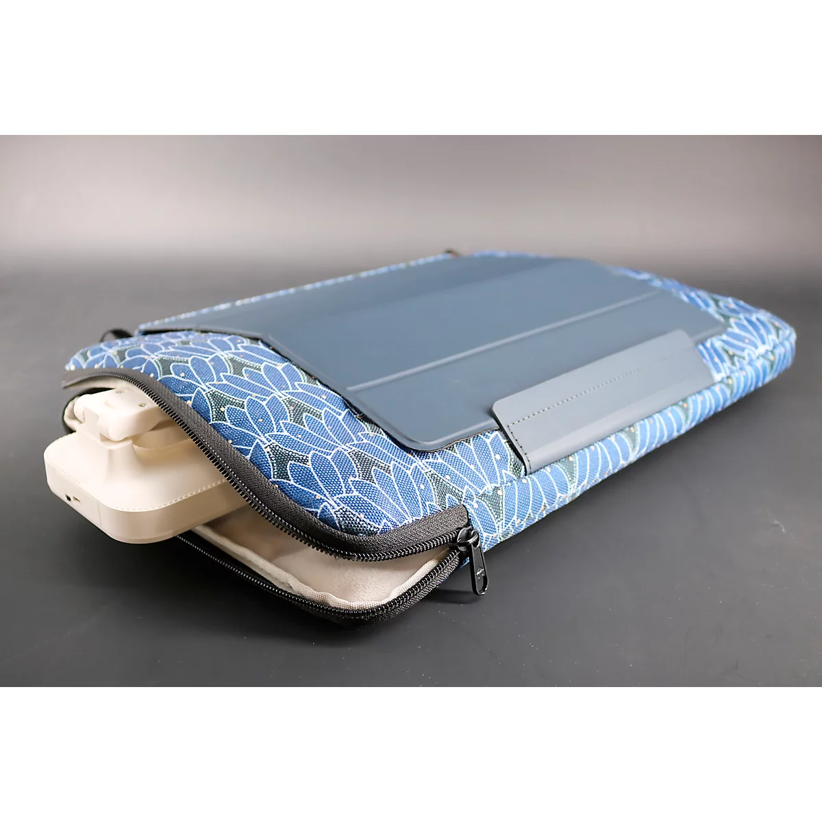 Blau-weiß gemusterte Tablethülle mit Tablet und Tastatur. Reißverschluss an der Seite.