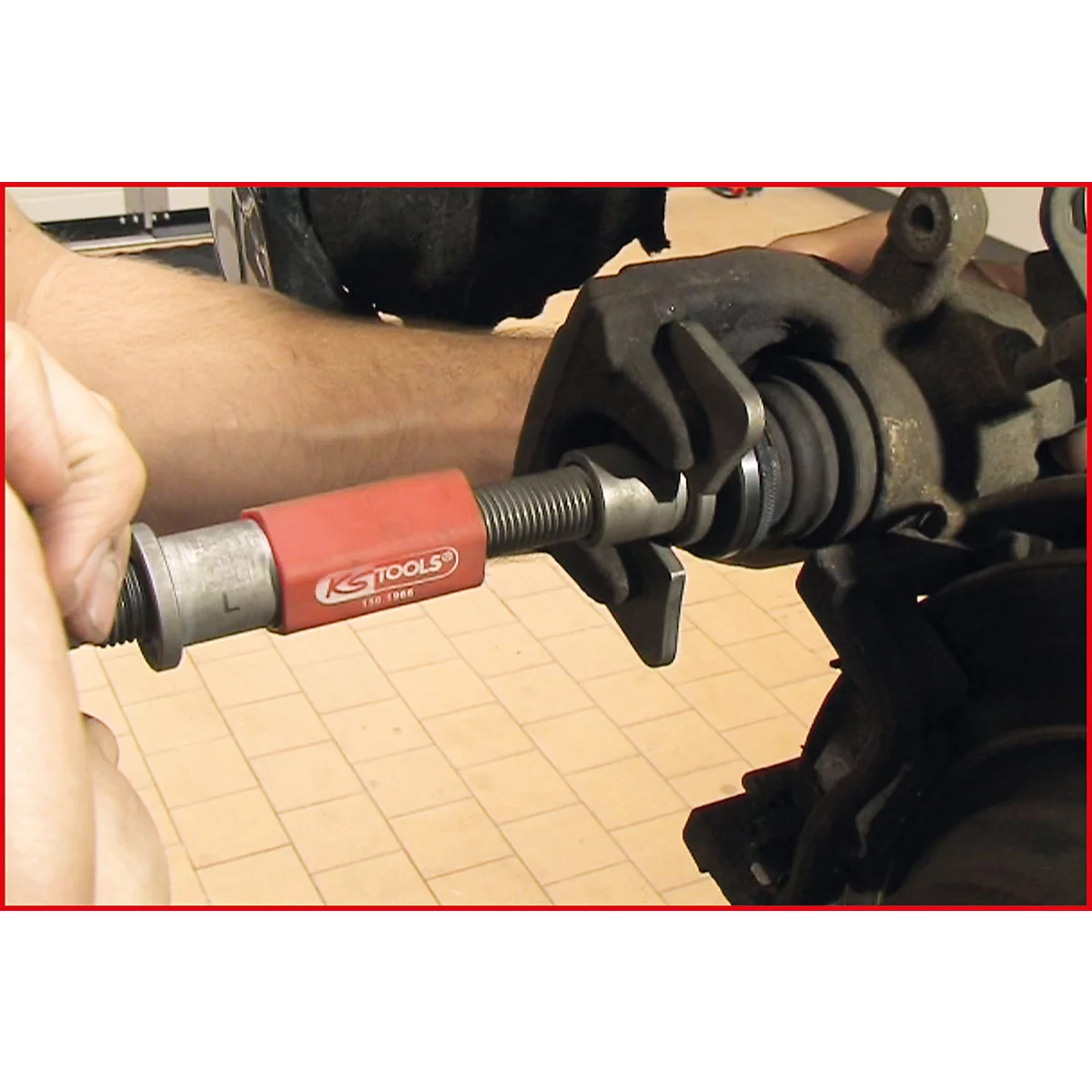 Eine Person verwendet ein KS TOOLS Werkzeug, um an einer Fahrzeugbremse zu arbeiten.