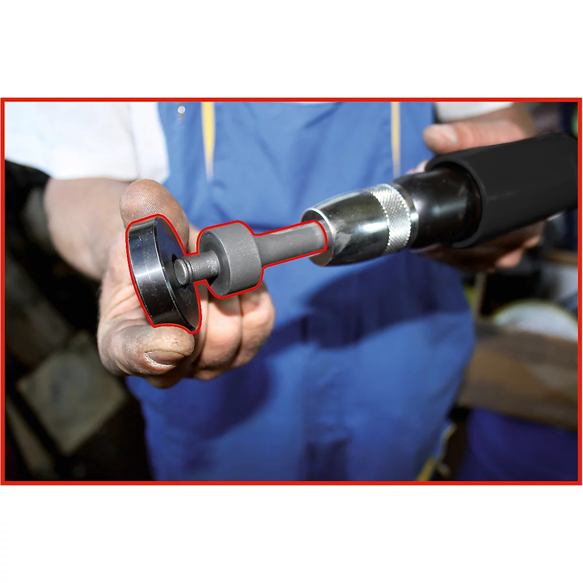Nahaufnahme einer Hand, die ein Werkzeug hält. Der Fokus liegt auf dem Aufsatz und der Spitze eines schwarzen Druckluftschraubers.