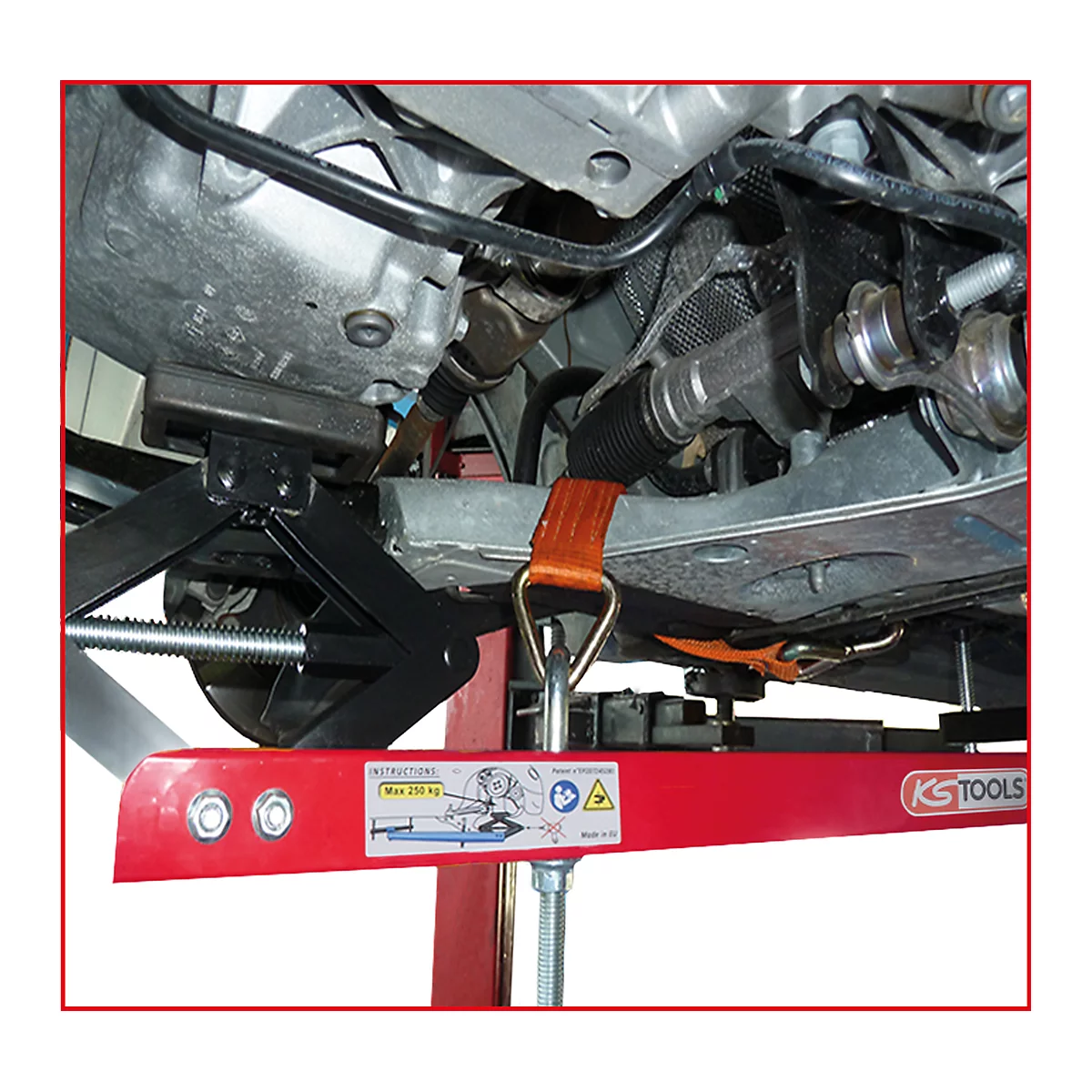 Ein roter Unterstellbock stützt ein Auto ab. Ein orangefarbenes Spanngurt ist befestigt. Auf dem Bock steht "KS TOOLS".