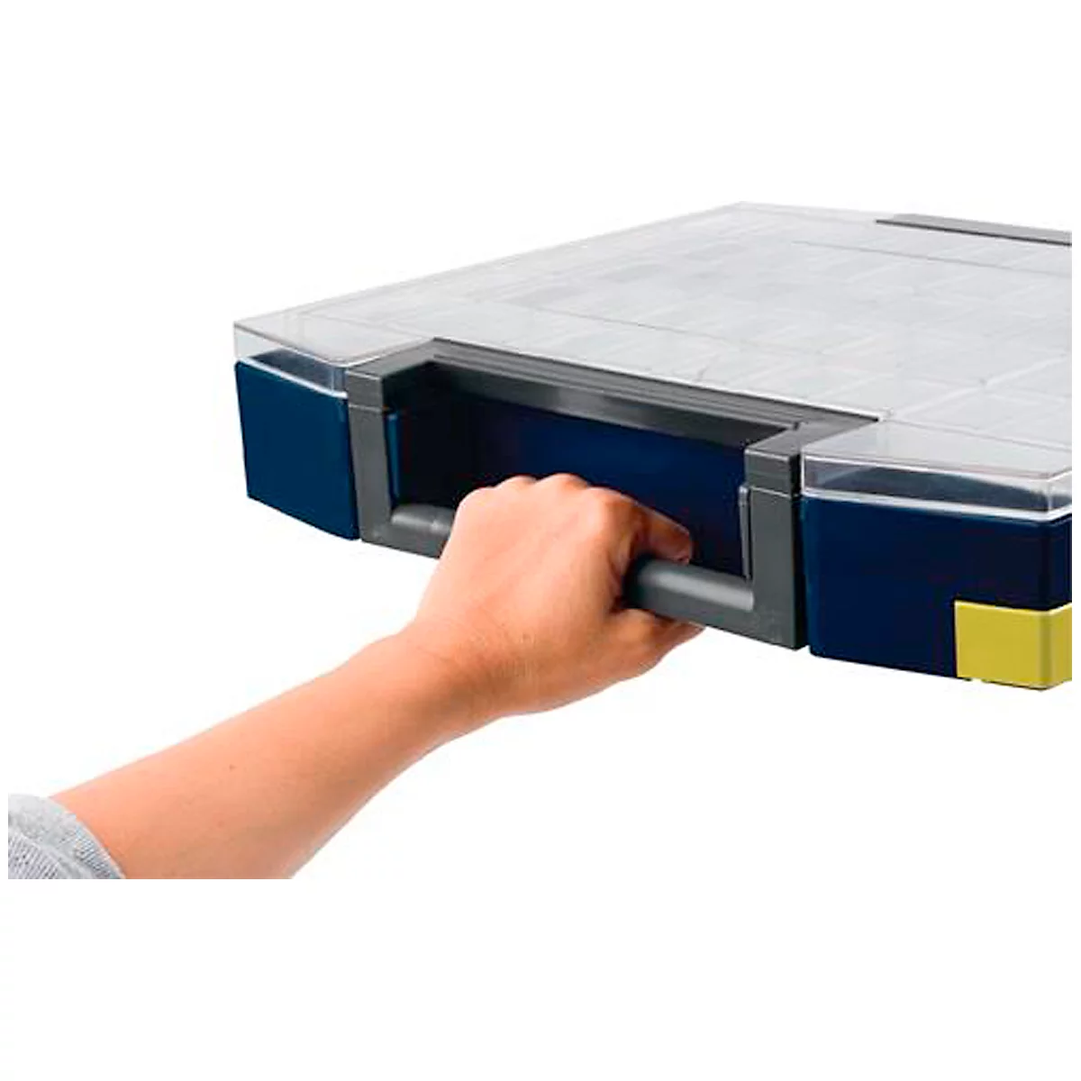 Une main tient une poignée grise sur une boîte de rangement bleue et transparente. Des détails jaunes et gris sont visibles.