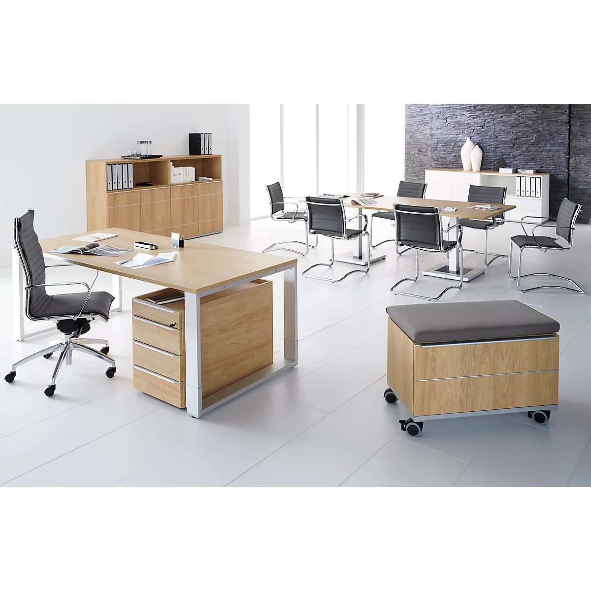 An office with wooden furniture, desk, chairs, and a meeting table. Bright atmosphere, white floor, grey chairs.