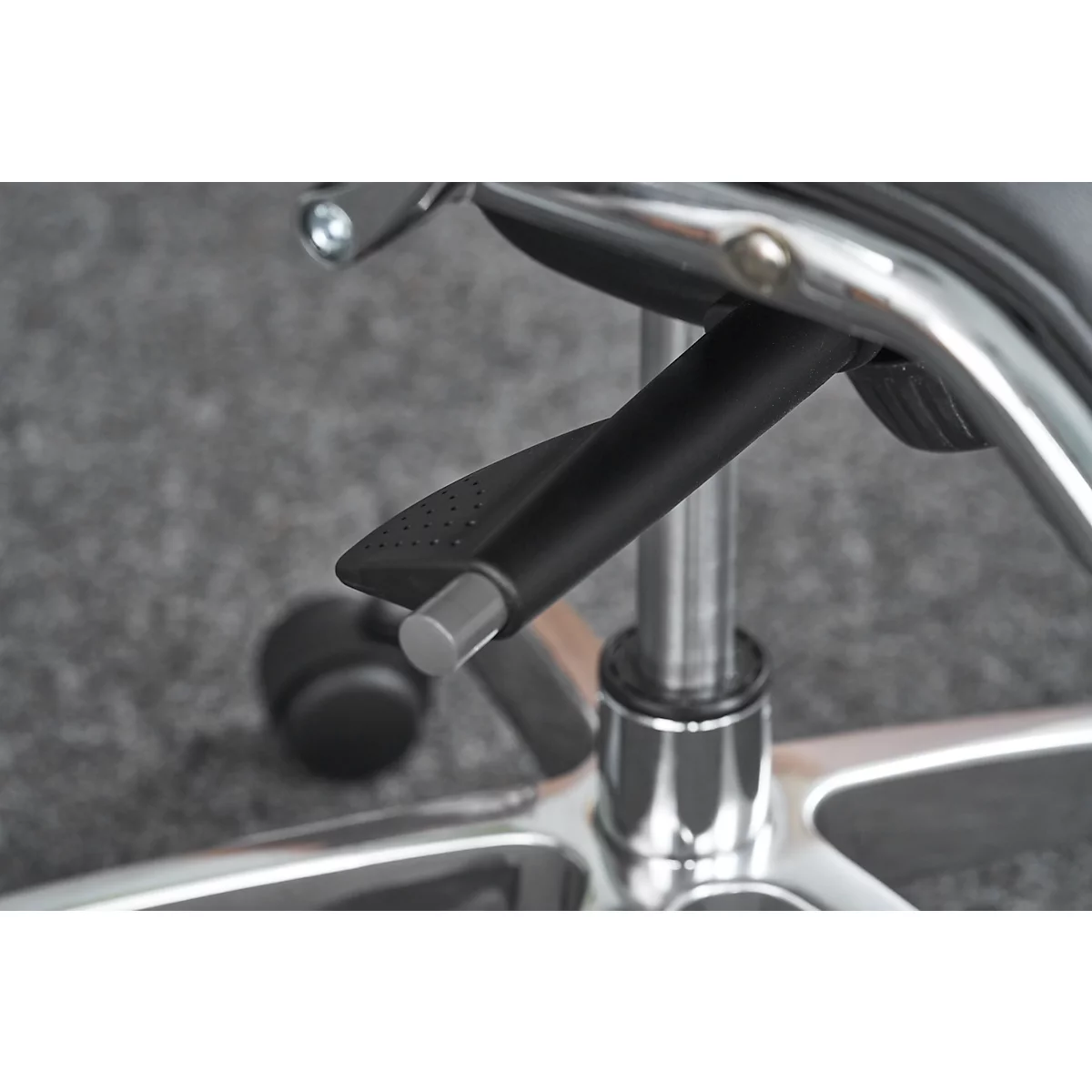 Close-up of a black, curved lever on a chrome office chair, likely used to adjust the height.