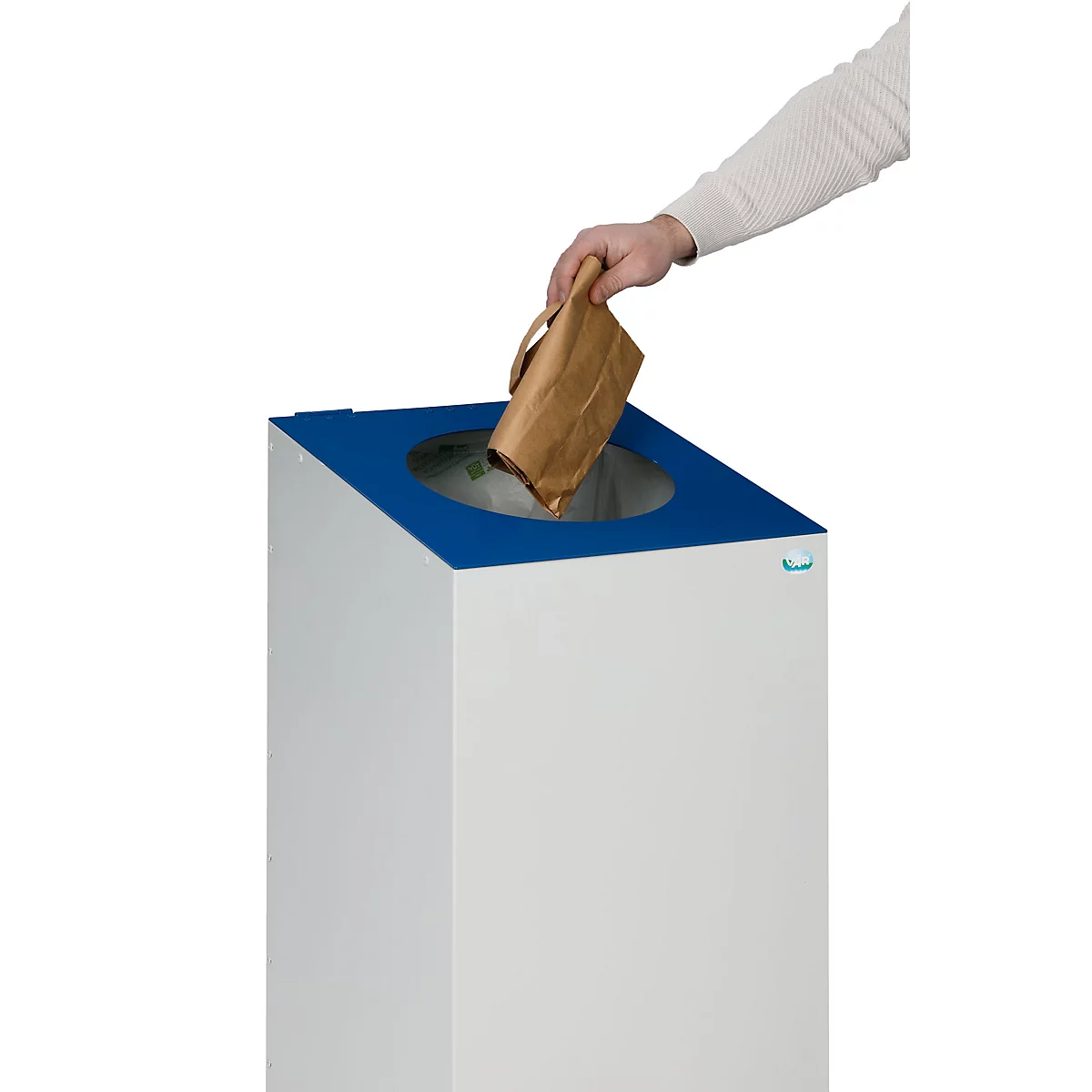 Een hand gooit een papieren zak in een wit-blauwe vuilnisbak.