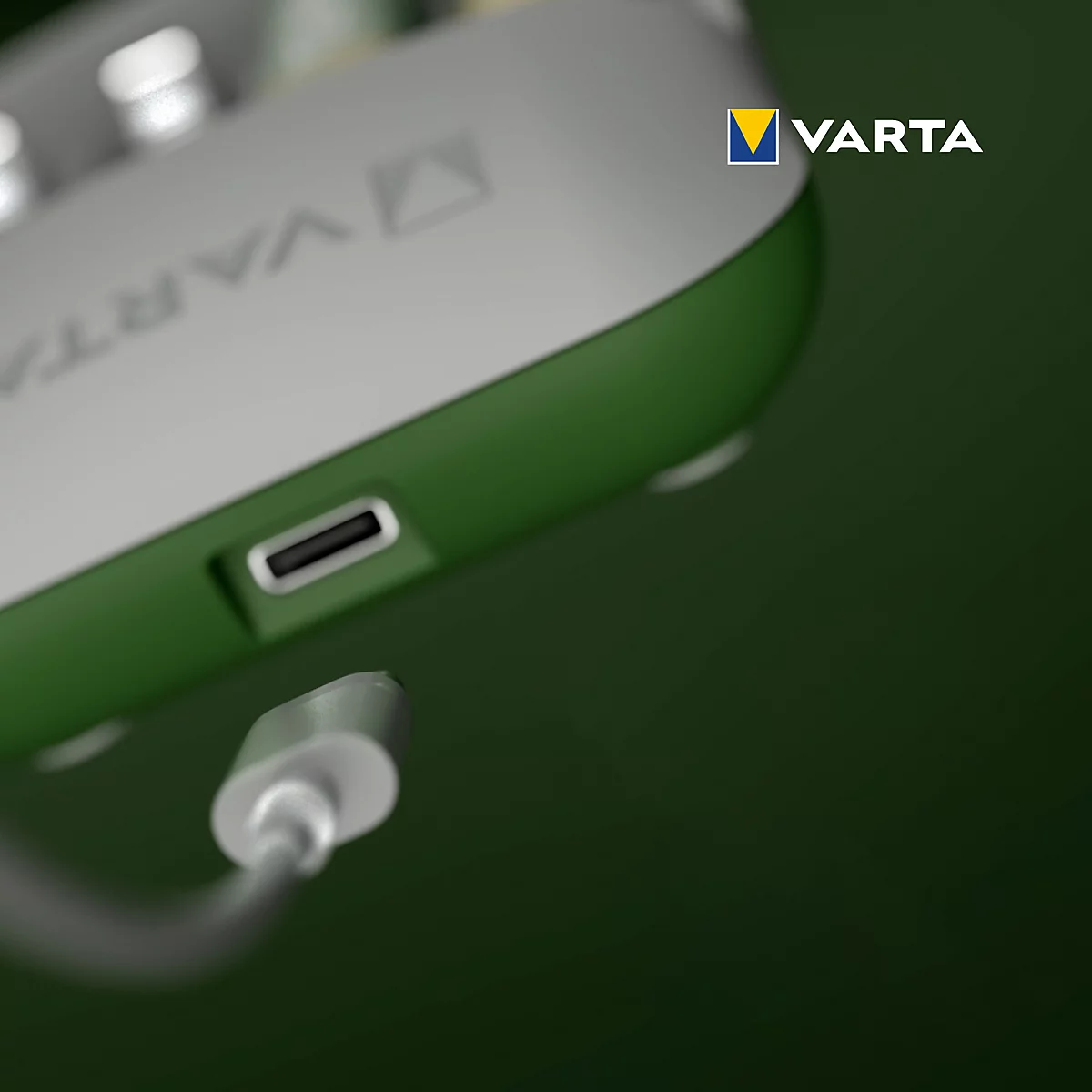 Close-up of a green charger with a USB-C port and a cable plugged in. The VARTA logo is visible.