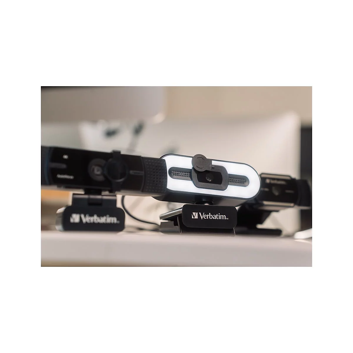 Drei Webcams mit Logos von Verbatim sind auf einer TischoberflÃ¤che platziert.