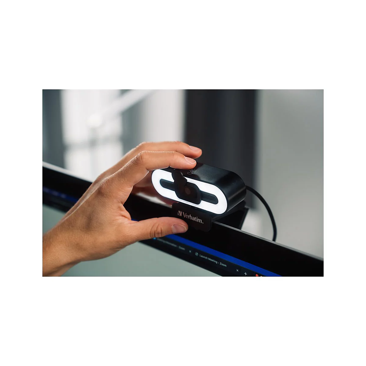 Hand berÃ¼hrt schwarze Webcam mit weiÃŸem LED-Ring. Verbatim-Logo unten.