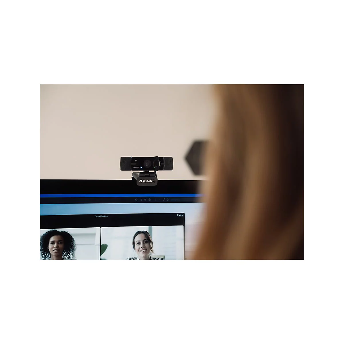Webcam auf Monitor, Videoanruf mit zwei Frauen. Blonde Haare im Vordergrund.