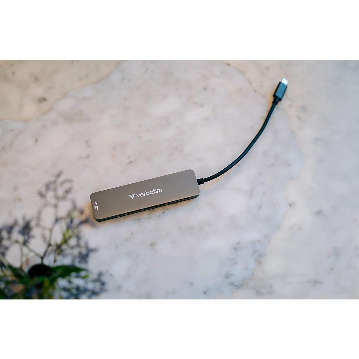 Grauer USB-C-Multiport-Adapter von Verbatim auf einem hellen Marmortisch liegend.