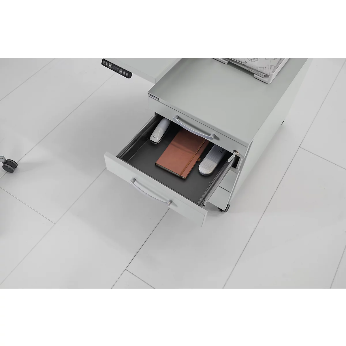 Bureau met open lade. Inhoud: notitieboek, muis, pennen.