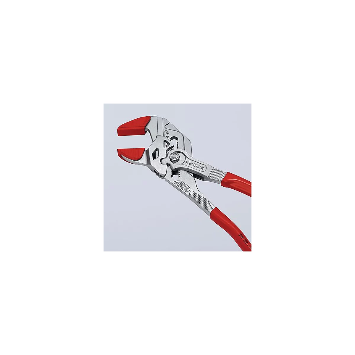 Close-up van een tang met rode handvatten en bekken. De merknaam KNIPEX is zichtbaar op de tang.