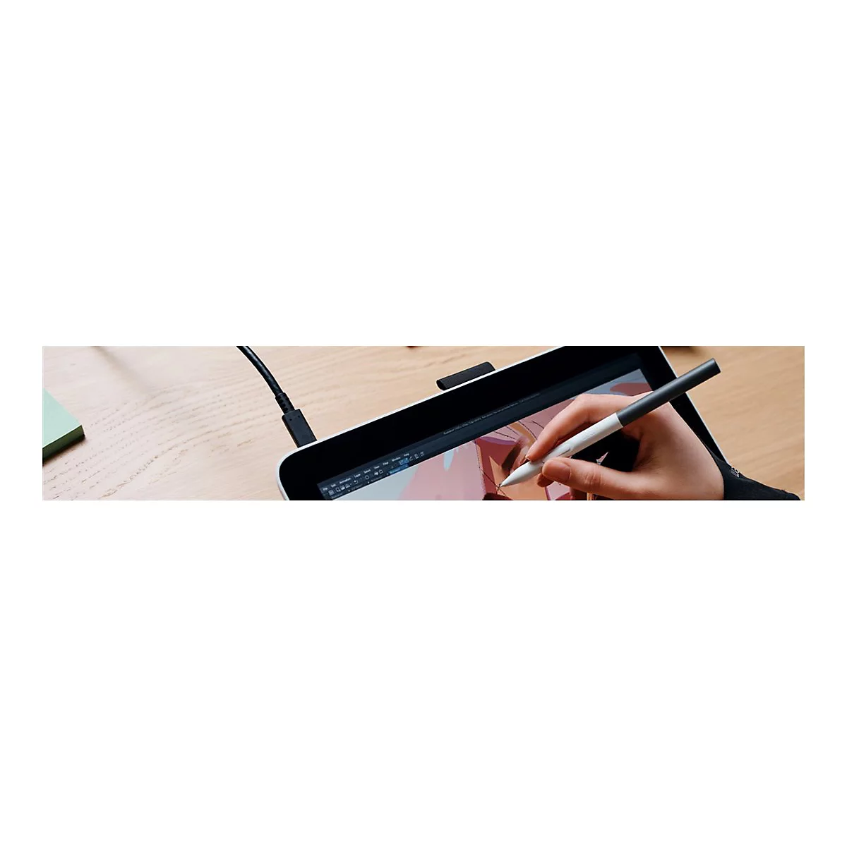 Nahaufnahme einer Hand, die einen Stift über einem Grafiktablett hält. Der Bildschirm zeigt eine Zeichnung. Der Stift hat eine schwarze und weiße Spitze.