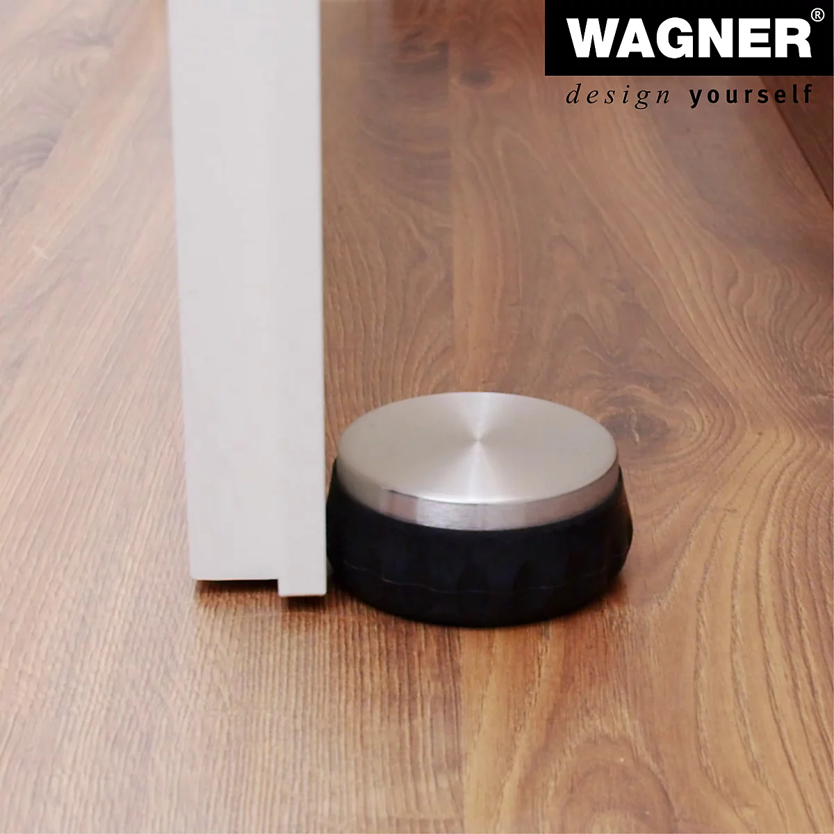 Een deurstopper met een roestvrijstalen oppervlak en zwarte rubberen ring staat voor een deur. Op de houten vloer staat een logo.