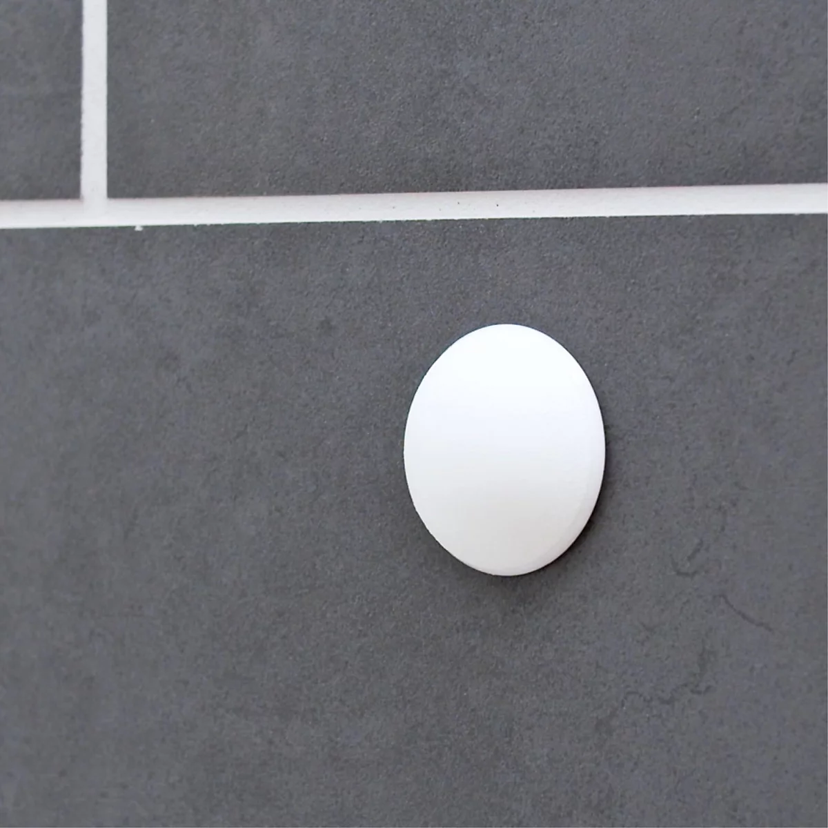 Ein weißes, ovales Element auf einem grauen Hintergrund. Einige Linien teilen den Hintergrund in Quadrate auf.