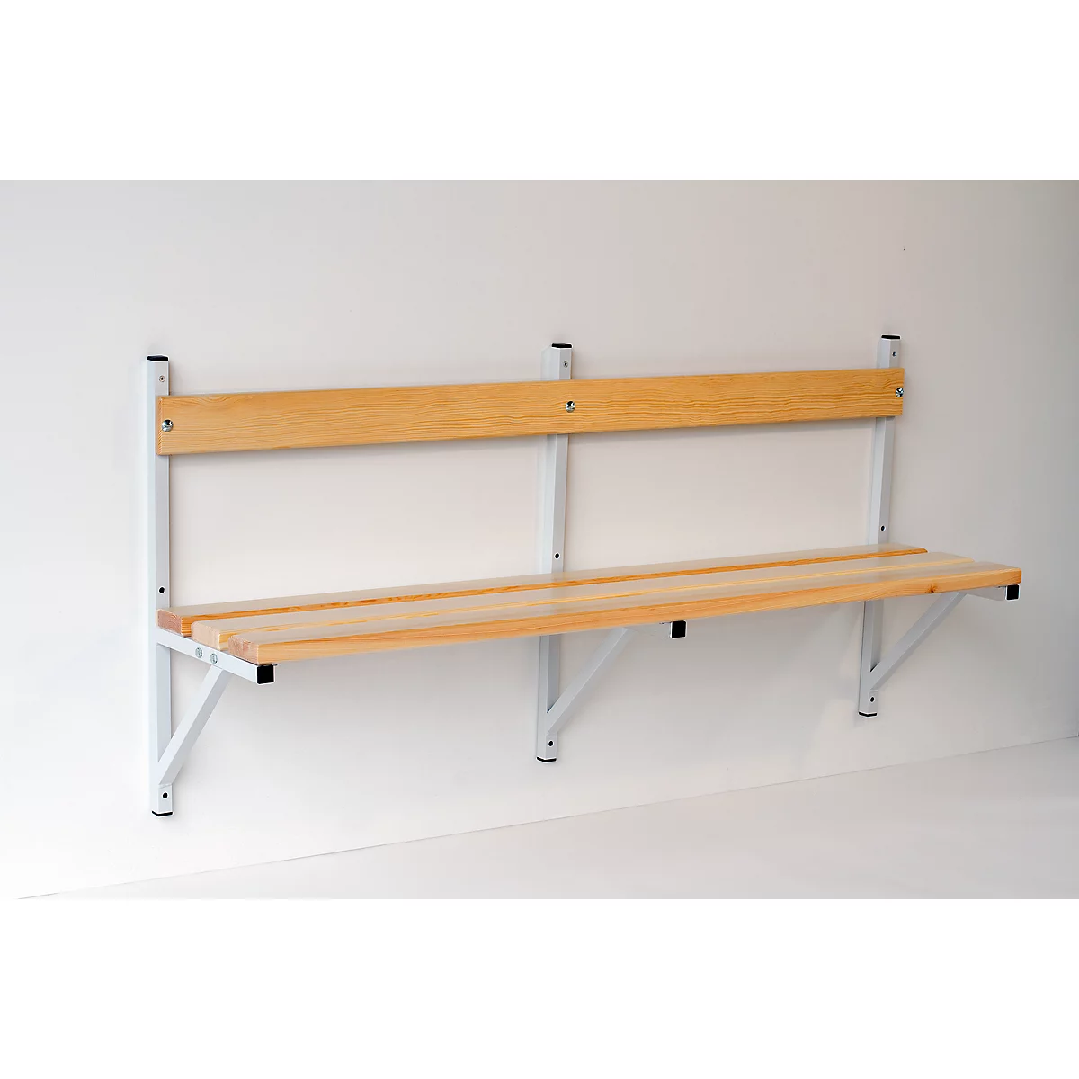 Light wood bench on white wall. The bench has a backrest, a seat and metal supports.